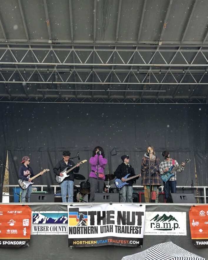 Imagine Music vocalists and their band performing together on an outdoor stage